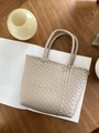 Detail der handgewebten Strohtasche mit klarer Netzstruktur auf einem weißen Album - Mini / Beige