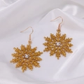 Golden snowflake drop earrings with glitter and crystals on white silk background - Golden Snowflake
