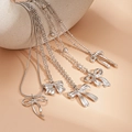 Detail of four silver layered necklaces with elegant bow pendants and polished finish - Bow / Five-Piece Set / Silver