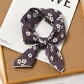 Purple cotton linen square scarf with white floral patterns tied on a magazine - Osmanthus Purple Base