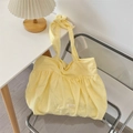 Gros plan du sac en toile jaune pâle plissé avec bandoulière nouée et étiquette Sorakka - Ramie Jaune Tendre