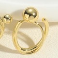 Makroaufnahme von minimalistischen goldenen Metallringen mit poliertem Doppelschleifen-Design - Einzelner Kupferperlenring