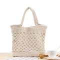Bolso tote de algodón tejido beige con diseño calado sobre una mesa de madera rústica - Blanco Roto