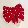 Detail of red velvet bow hair claw clip with elegant white pearls on stone stand - Velvet Pearl Bow / Burgundy