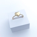 Makroaufnahme eines goldenen Herzrings mit gedrehtem Band auf weißem Ständer - US 8 / Gedrehtes Kleines Herz / Gold