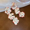 Detail of tiered white floral drop earrings with red edges and golden hooks on silk cloth - White Red Edge (HE28465-2)