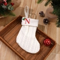 White knit Christmas stocking featuring red letter N embroidery and holly detail - Letter N