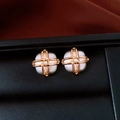 Macro view of square earrings with white gemstone and golden cross-wire detail - Square / Gold Plated White