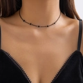 Close-up of a gothic black beaded choker with delicate tassels worn on a lace neckline - 08 Black Simple Bead Chain Necklace