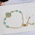 Macro dettaglio del bracciale regolabile placcato oro 18K con cammeo della Vergine Maria - Celeste