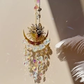 Detail of sun and moon suncatcher reflecting colorful rainbow spots on a wall - Flame Sun AB Color