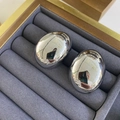 Detailed macro view of silver oval stud earrings on a grey velvet jewelry display tray - Silver Large