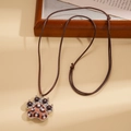 Détail du pendentif patte léopard avec coussinets noirs et cordon tressé marron - Style Patte Imprimé Léopard (Collier-Marron)