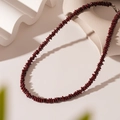 Dettaglio ravvicinato della collana vintage con perline rosso scuro su supporto bianco - Perline di Ossidiana Rossa