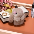 Brown mink fur rabbit keychain with golden ring on a gift box background - 11cm / Khaki