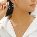 Close-up of elegant silver snowflake pendant necklace and earrings set with rhinestones - 23 Earrings + Necklace Style
