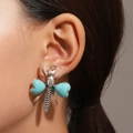 Detail of vintage silver insect earring with heart turquoise stones worn on a model - Insect Stud Style (K-1192) / Antique Silver
