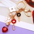 Golden flower keychain with white enamel petals and red crystal heart charm pendant - Gemstone Heart Clover