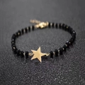 Macro detail of black faceted bead bracelet with a gold star pendant and lobster clasp - Gold Star