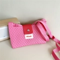 Detail of pink knitted crossbody bag with diamond texture and red canvas clasp - Rose Pink