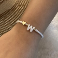 Handmade beaded bracelet featuring white matte beads, gold heart charm, and letter W - Letter W