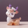Cute brown resin fawn figurine with purple antlers and flower decor in a sitting pose - Lying Winking Deer (008)