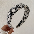 Padded black and white tweed wide headband with a handmade label on a beige background - Style B/Black White Woven