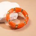Détail du bracelet gourmette en résine orange et métal doré sur pierre blanche - Texture Marbre Orange (HB4173)