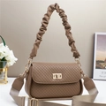 Close-up of brown quilted crossbody bag with wide strap and gold twist lock detail - Coffee