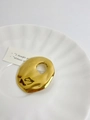 Close-up of a gold irregular hollow brooch with molten lava texture on a white shell tray - 7 Water Ripple Gold (Y-349)