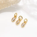 Nahaufnahme von goldenen Zirkonia-Anhängern für DIY-Schmuck mit dekorativer Muschel - Weißer Zirkonia