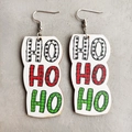 Detail der Weihnachts-Ohrringe mit Ho-Ho-Ho-Text in festlichen roten und grünen Karomustern - HO HO HO Karo Buchstaben