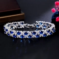 Elegant silver bracelet with blue sapphire zircons and white crystals on black background - Sapphire Blue