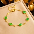 Bracciale dorato con pietre preziose verdi ovali su sfondo elegante in seta dorata - Bracciale Con Cinque Pietre Preziose (B1436)