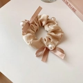 Gros plan sur chouchou en satin beige avec de grandes perles et double nœud ruban - Champagne 45#