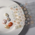 Close-up of FEB-647 5D embossed floral nail stickers with orange and blue flower textures - FEB-647