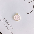 Detail of pink enamel round charm with golden letter O and metallic ring for DIY jewelry - Letter O