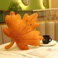 Deep orange maple leaf plush pillow with smiling face on marble table in cafe setting - Maple Leaf