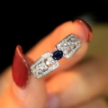 Elegant silver ring with oval blue sapphire and pavé-set zircons on dark background - US 7 / White Gold