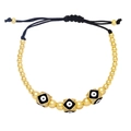 Close-up of golden beaded evil eye bracelet with adjustable black drawstring closure - Black