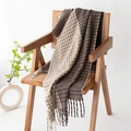 Plaid scarf in dark brown and beige with tassels draped on a vintage rattan chair - Coffee Brown