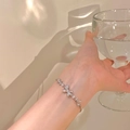 Dettaglio del bracciale a farfalla d'argento con zirconi indossato da una modella - Bracciale