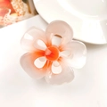 Close-up of translucent gradient frangipani hair claw clip with metal spring detail - 5-Petal Flower Orange White