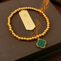 Detalle de pulsera bañada en oro de 18k con trébol verde y colgante de moneda grabada - Oro - Trébol Etiqueta de Oro de Herencia