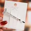 Close-up of a silver mermaid tail hair clip with sparkling rhinestones on a card - Silver Mermaid Tail