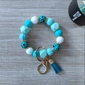 Detail of beaded keychain bracelet with silicone beads, gold clasp and navy blue tassel - Teal