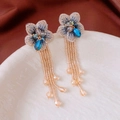 Detailed macro view of embroidered floral tassel earrings with blue beads and champagne gold finish - Blue-Champagne