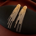Close-up of golden tassel drop earrings with delicate bead chains on a black matte stand - Gold Bead Chain Dense Cluster Tassel Style