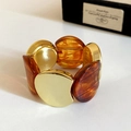 Close-up of golden metal and amber resin acrylic links on a stretch bracelet - Gold-Dark Coffee
