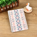 Spiral notebook featuring orange and blue geometric folk patterns on a wooden desk - A5 / Bohemian Style 3
